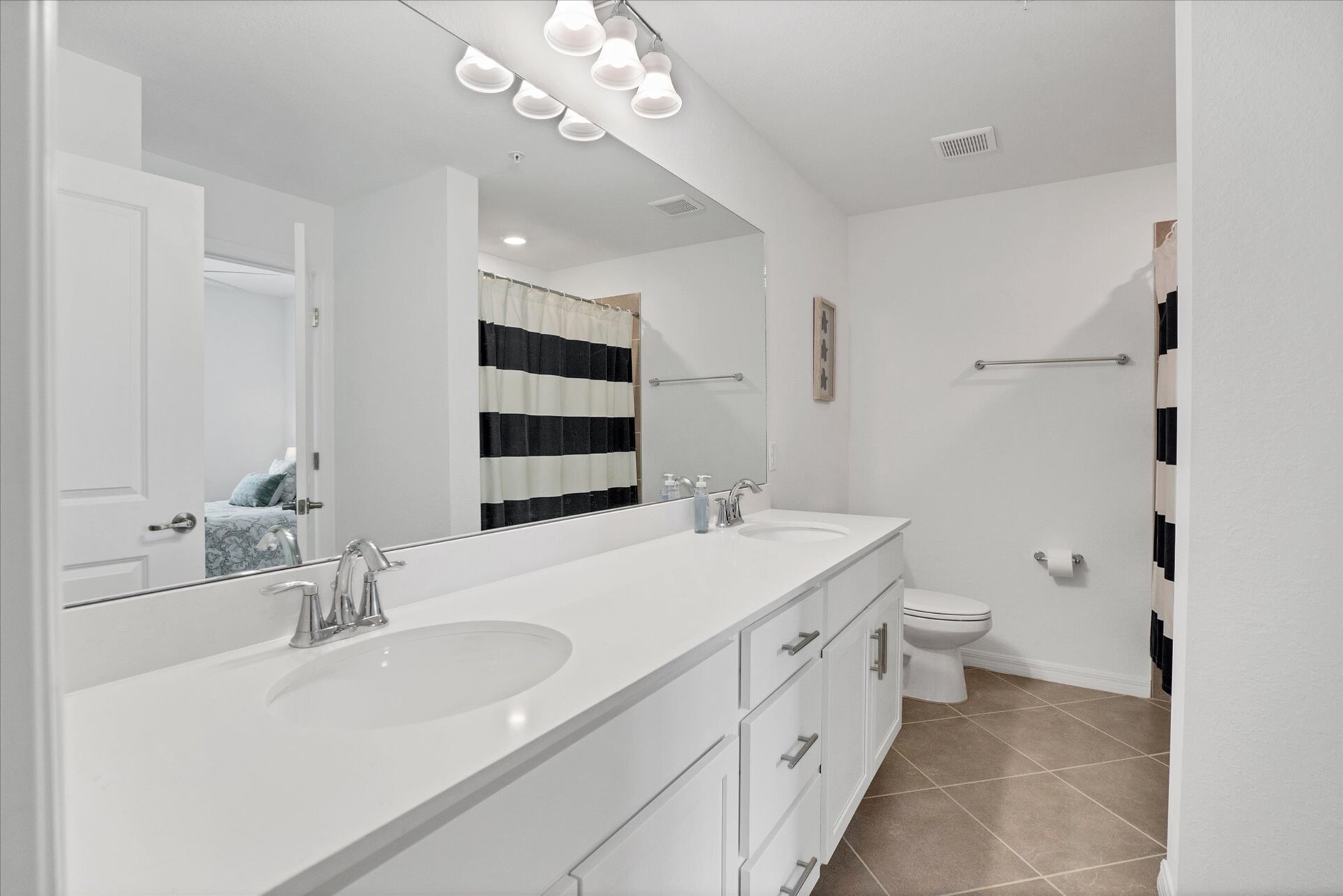 Guest bathroom with double vanities and shower/tub combo