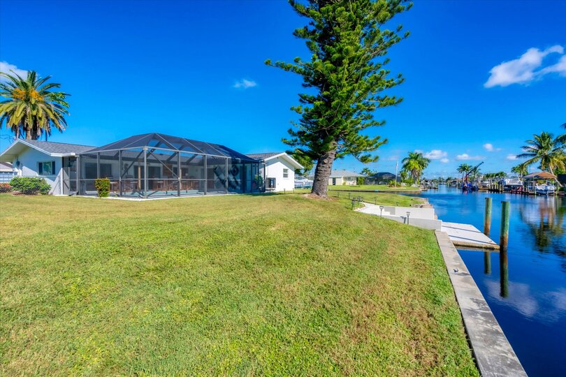 Large backyard leading to dock and canal