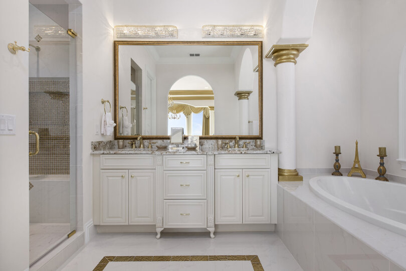The en-suite bathroom is elegantly appointed and features both a soaking tub and glass shower