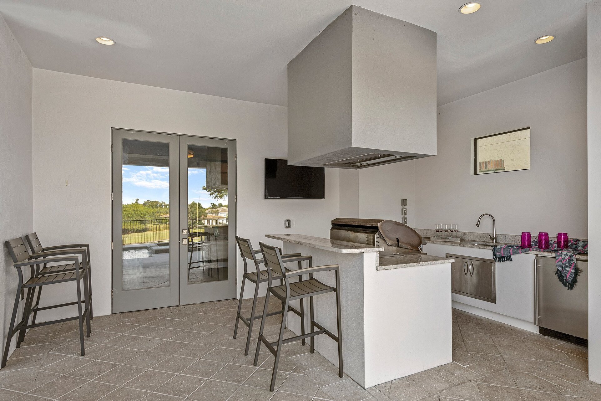 A summer kitchen is located underneath the covered lanai for delicious BBQ meals