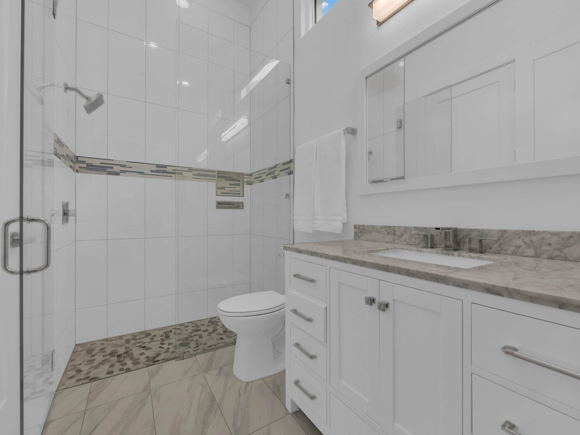 The bathroom has a tub/shower combination and a beautiful marble counter top