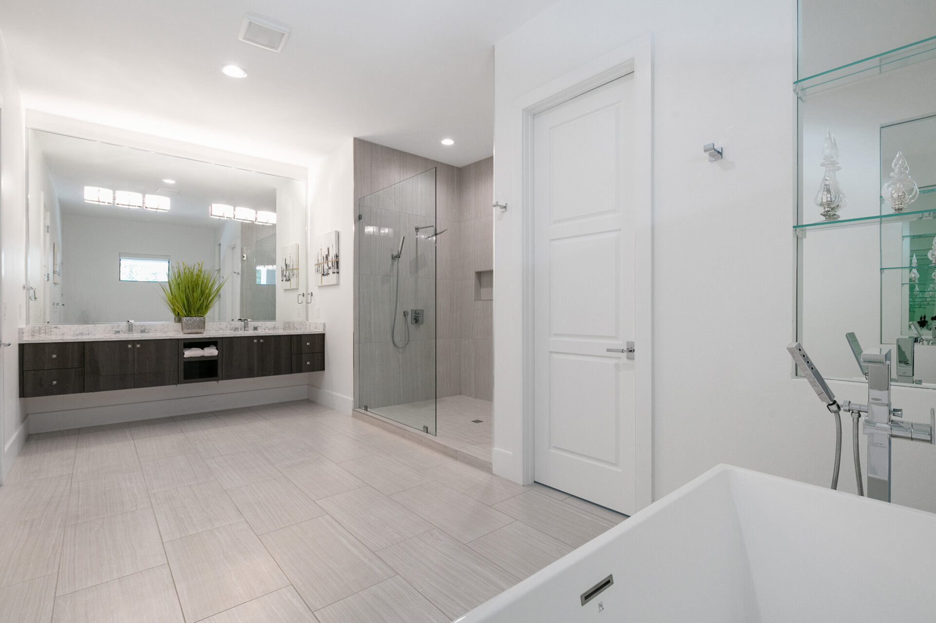 The ensuite bathroom has dual vanities, a walk-in shower, and a garden tub