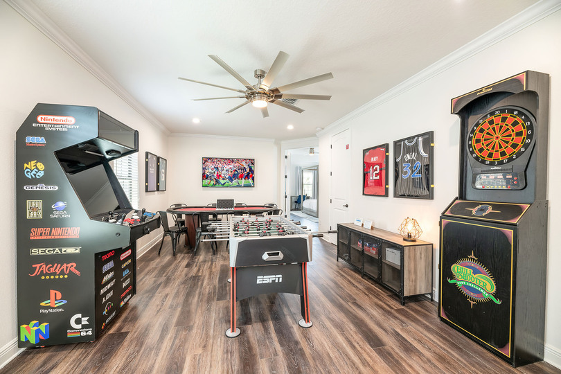 The entertainment loft features a dartboard, a foosball table, a multi-game arcade, and a professional poker table