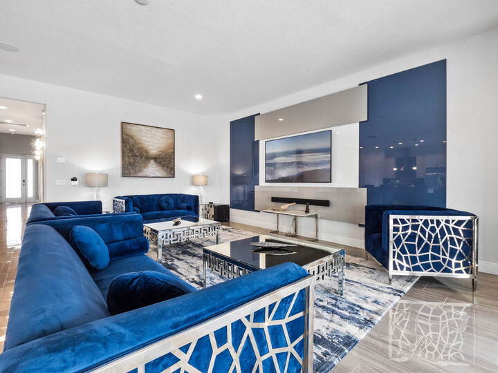 Sink into serenity in our expansive living room, where the tranquil blue tones of the couch harmonize with the plush carpet beneath, inviting you to unwind in absolute comfort.