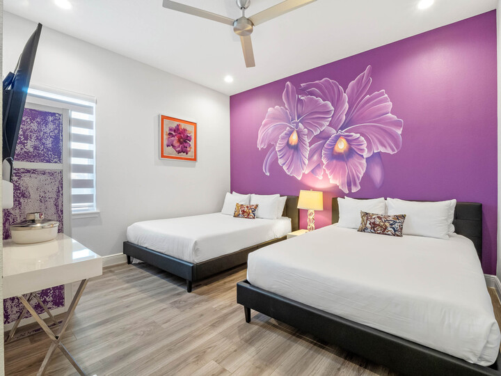 Discover a dreamy escape in our bedroom adorned in a calming shade of purple, complemented by the enchanting presence of a beautiful flower painting.
