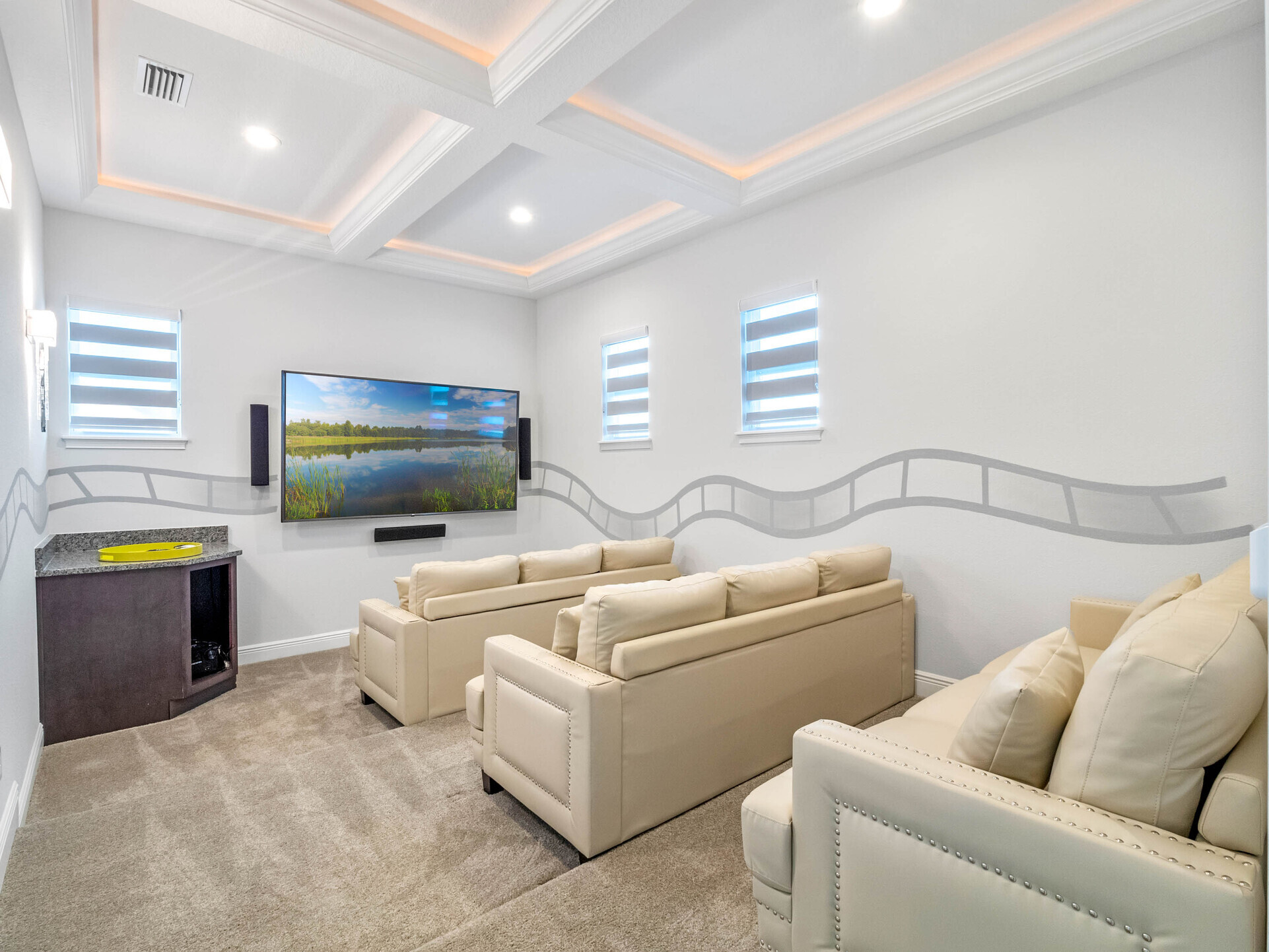 The theater boasts three comfortable sofas, providing seating for up to nine guests, all positioned perfectly for enjoying the immersive experience of a 120-inch smart TV and surround sound system.