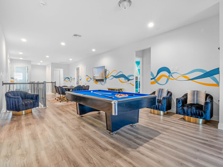 The open space on the second floor is a hub of entertainment, featuring a pool table, poker table, and arcade games, ensuring endless fun for everyone.