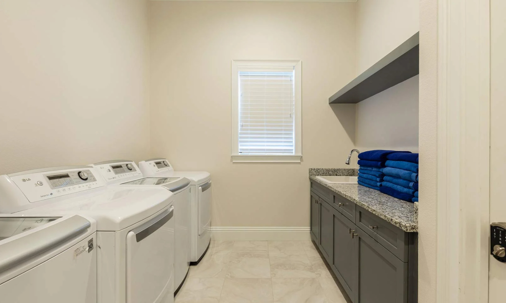The laundry room has 2 sets of washers and dryers