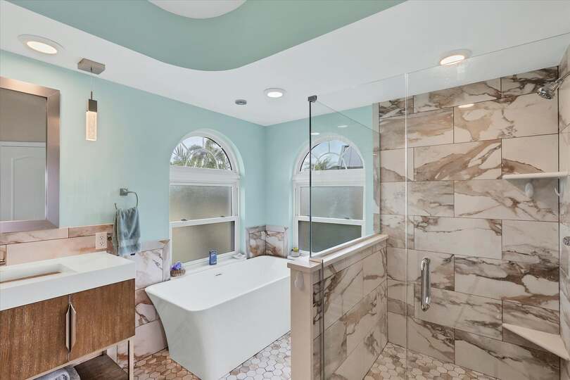 Primary attached bathroom with large walk-in shower, soaking tub, and double vanities