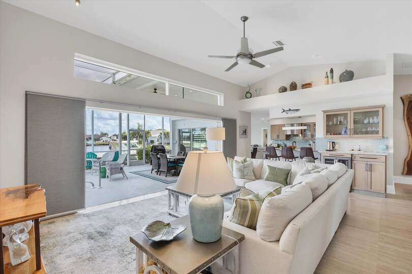 Family room overlooking sparkling pool and canal beyond. Features comfy seating and a 56-inch Smart TV