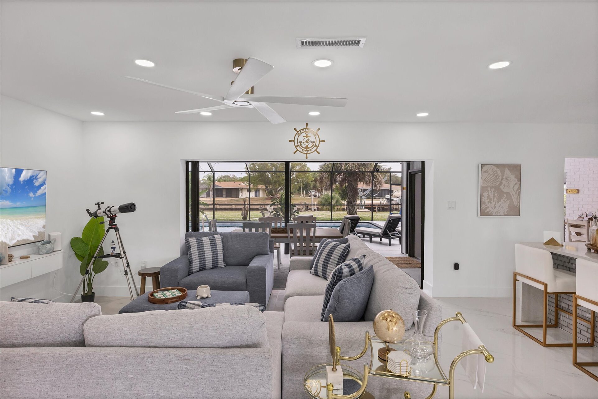 Living room overlooking the pool & canal. Living features ample & comfy seating, and 65-inch Smart TV