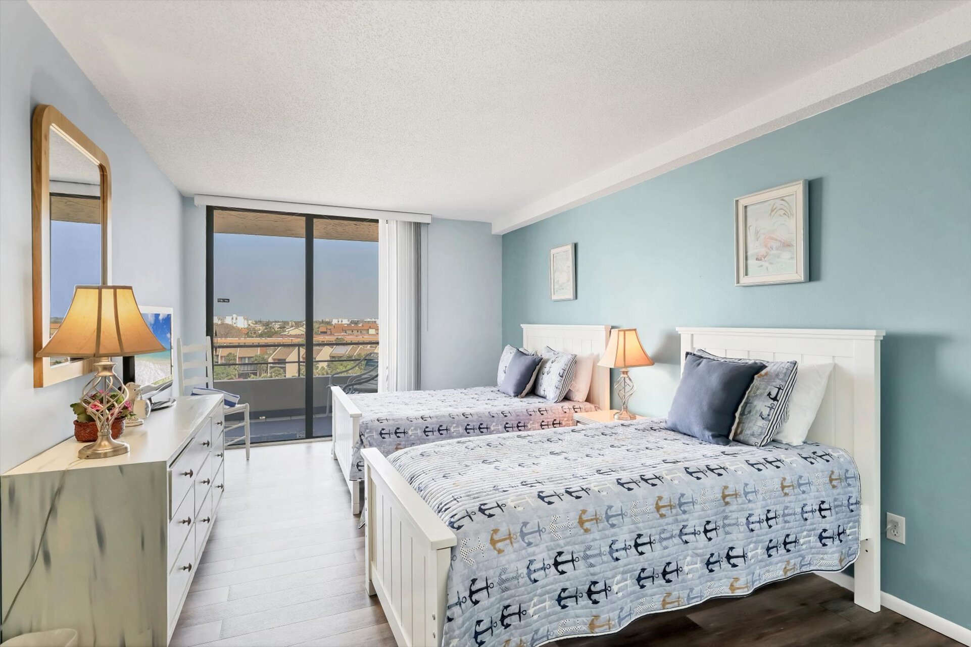 Guest Bedroom with one Queen Bed, one twin bed, balcony access, and a 32" TV
