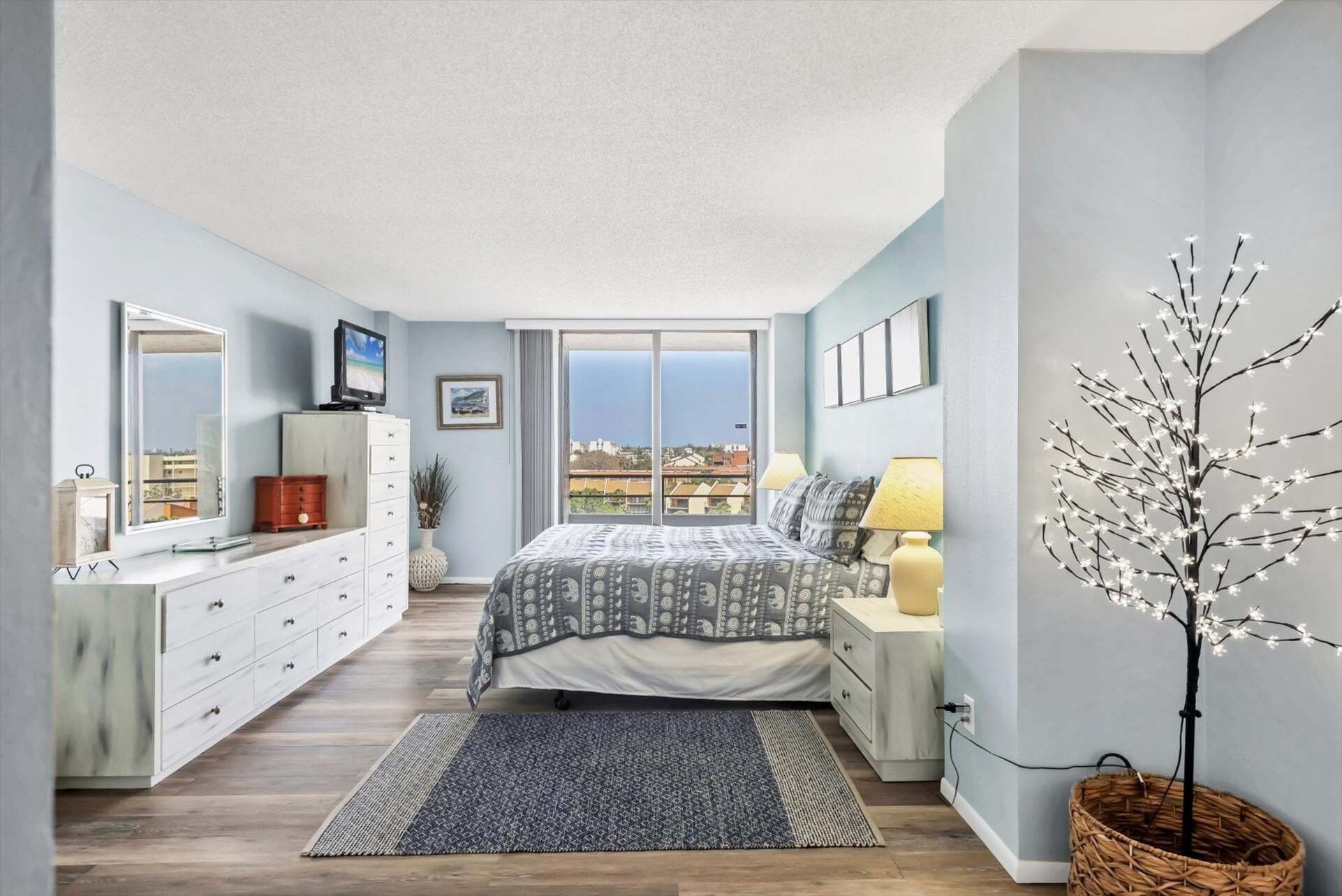 Primary Bedroom with king bed, en suite, balcony access, and a 32" TV