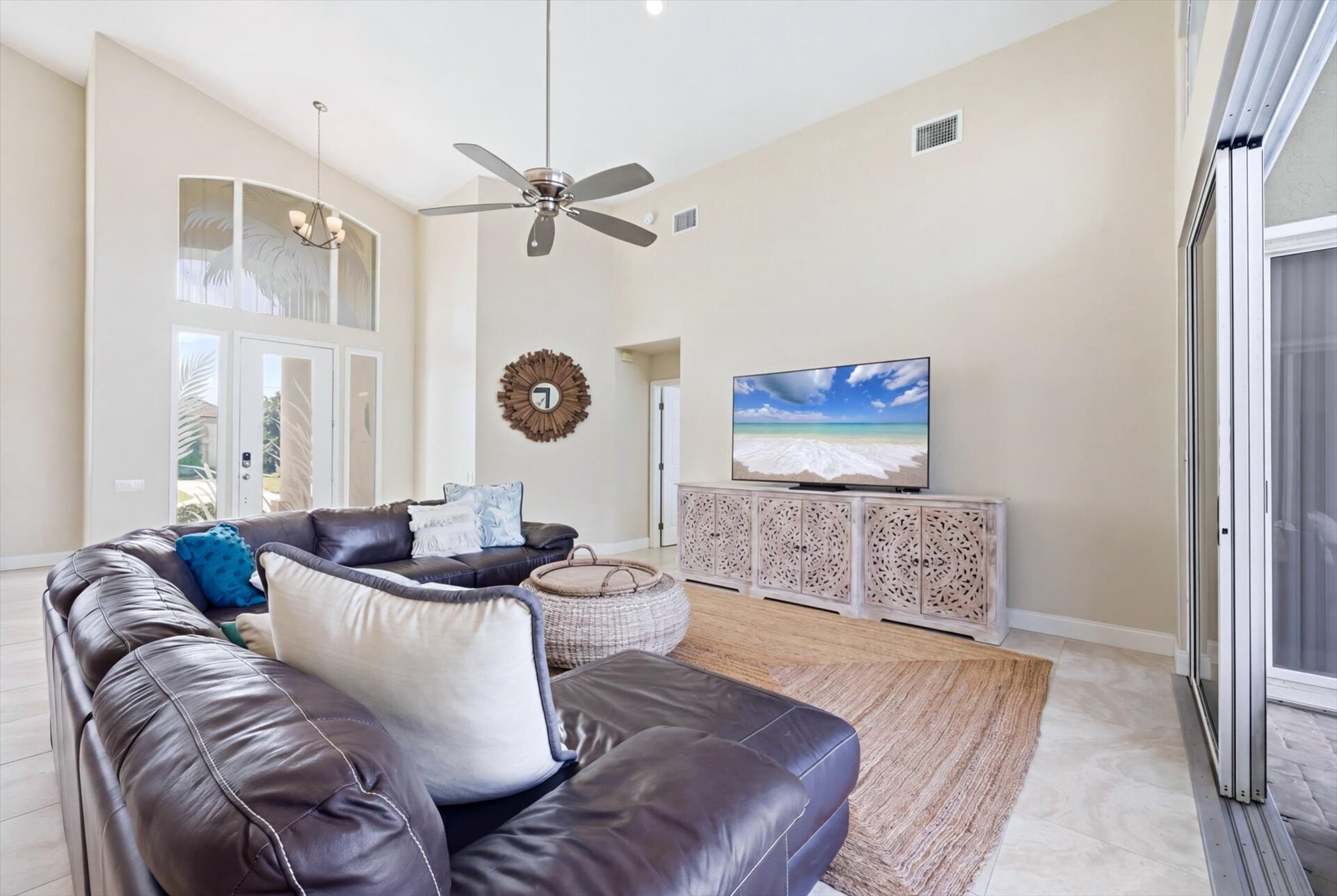 Family room with large sectional sofa, lanai access and 75-inch Smart TV