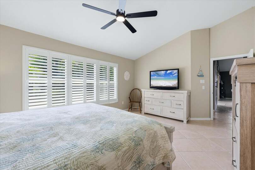 Primary bedroom with king bed, attached bathroom, and 46-inch smart TV