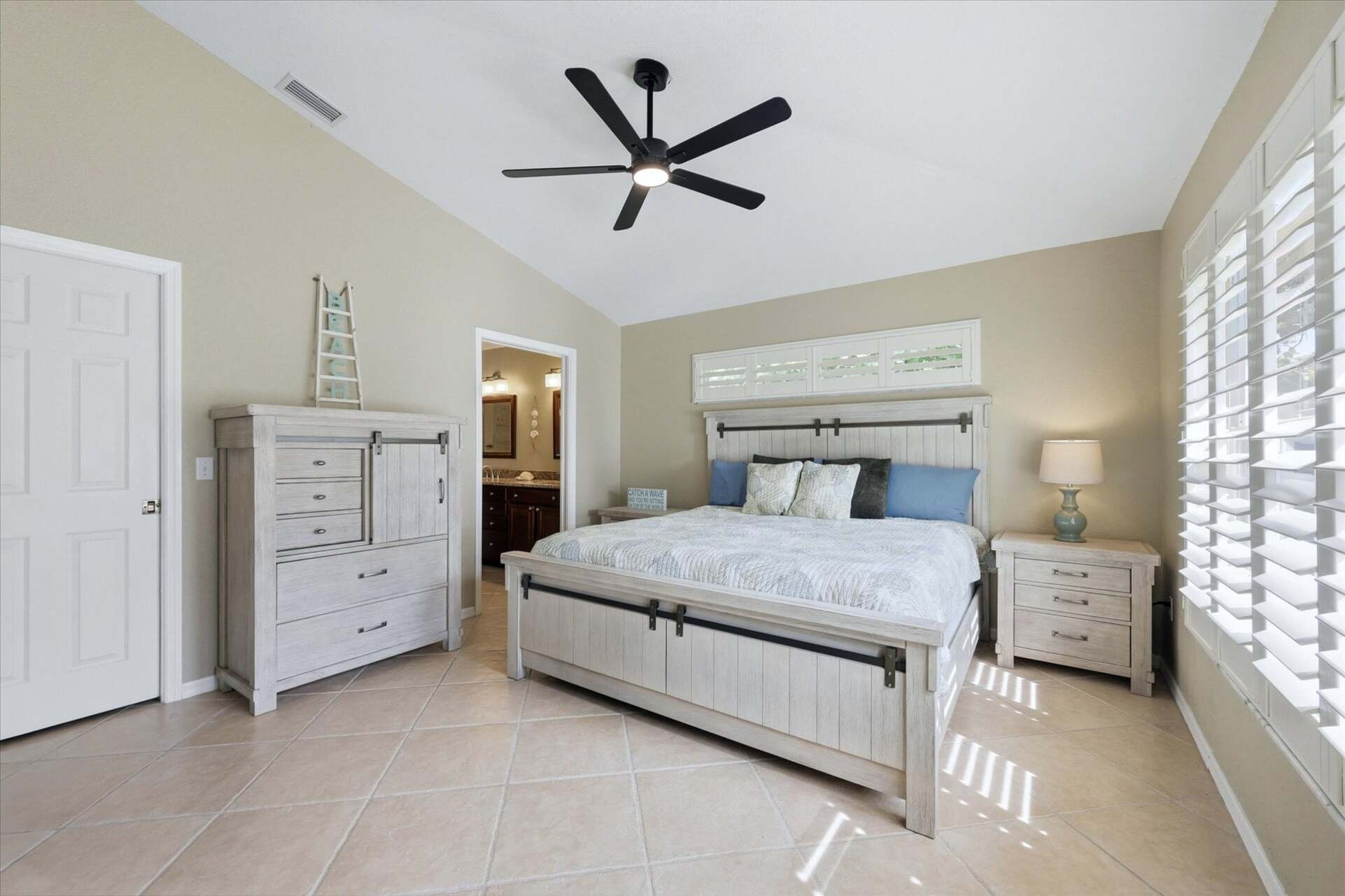 Primary bedroom with king bed, attached bathroom, and 46-inch smart TV