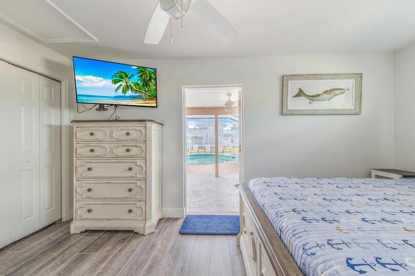 Guest bedroom 3 (off of garage) with full-size bed, attached bathroom, lanai access, 43-inch Smart TV, and private entry