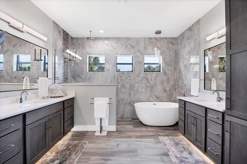 Primary bedroom's attached bathroom with large walk-in shower, double vanities and a relaxing soaking tub