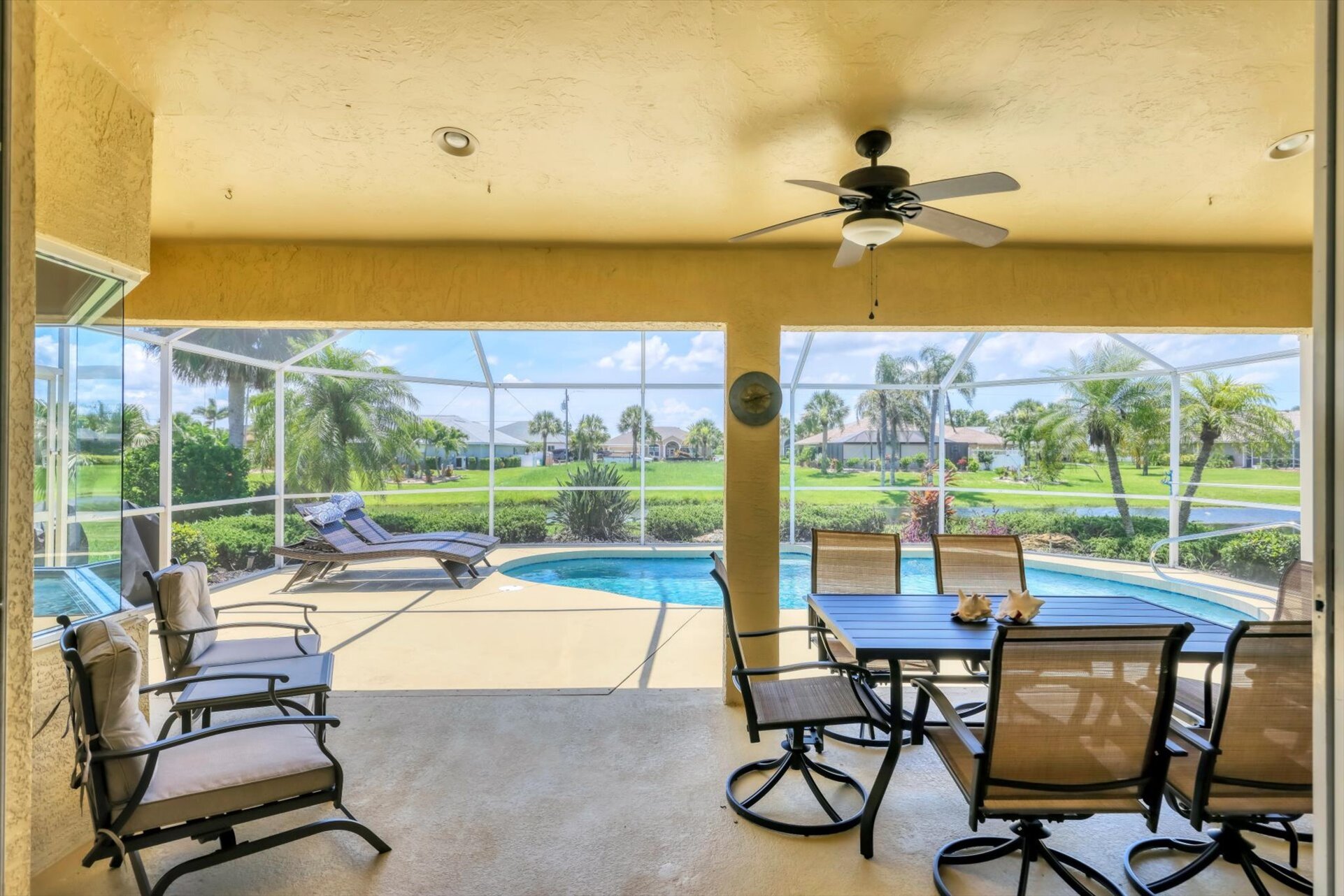 Large outoor living area overlooking the sparkling pool and canal