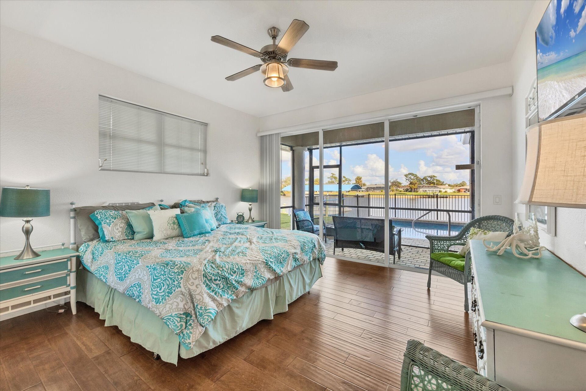 Downstairs guest bedroom beautiful pool & water view. Bedroom features a king bed, lanai access and 50" Smart TV