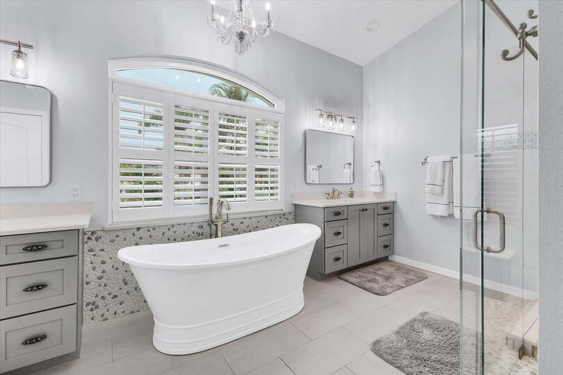 Primary en suite with large walk-in shower, soaking tub, and double vanities