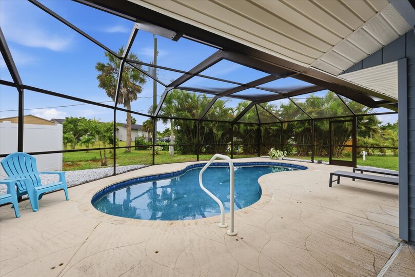Outdoor living space overlooking sparkling pool. Also features outdoor shower, 2 sun loungers, 55-inch Smart TV, and a propane/pellet BBQ grill. Pool Size 25' x 12' x 5.5'D