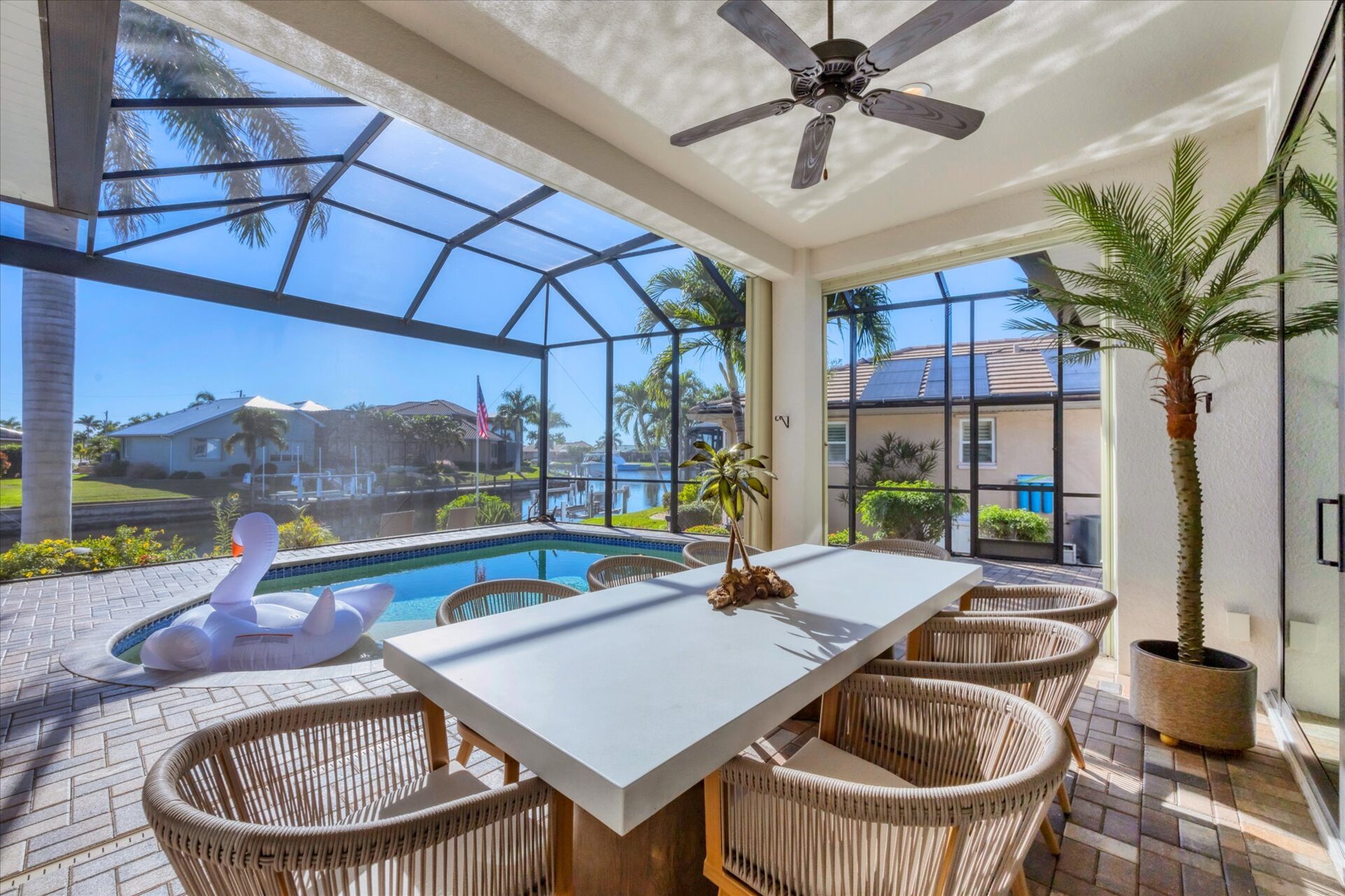 Gorgeous outdoor living space overlooking the sparkling private pool and canal beyond. Great for entertaining. This space features an outdoor kitchen, ample seating, grill, dining table that seats 8, and 50-inch Smart TV