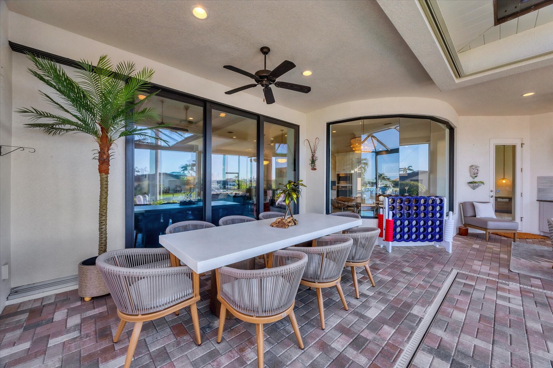 Gorgeous outdoor living space overlooking the sparkling private pool and canal beyond. Great for entertaining. This space features an outdoor kitchen, ample seating, grill, dining table that seats 8, and 50-inch Smart TV