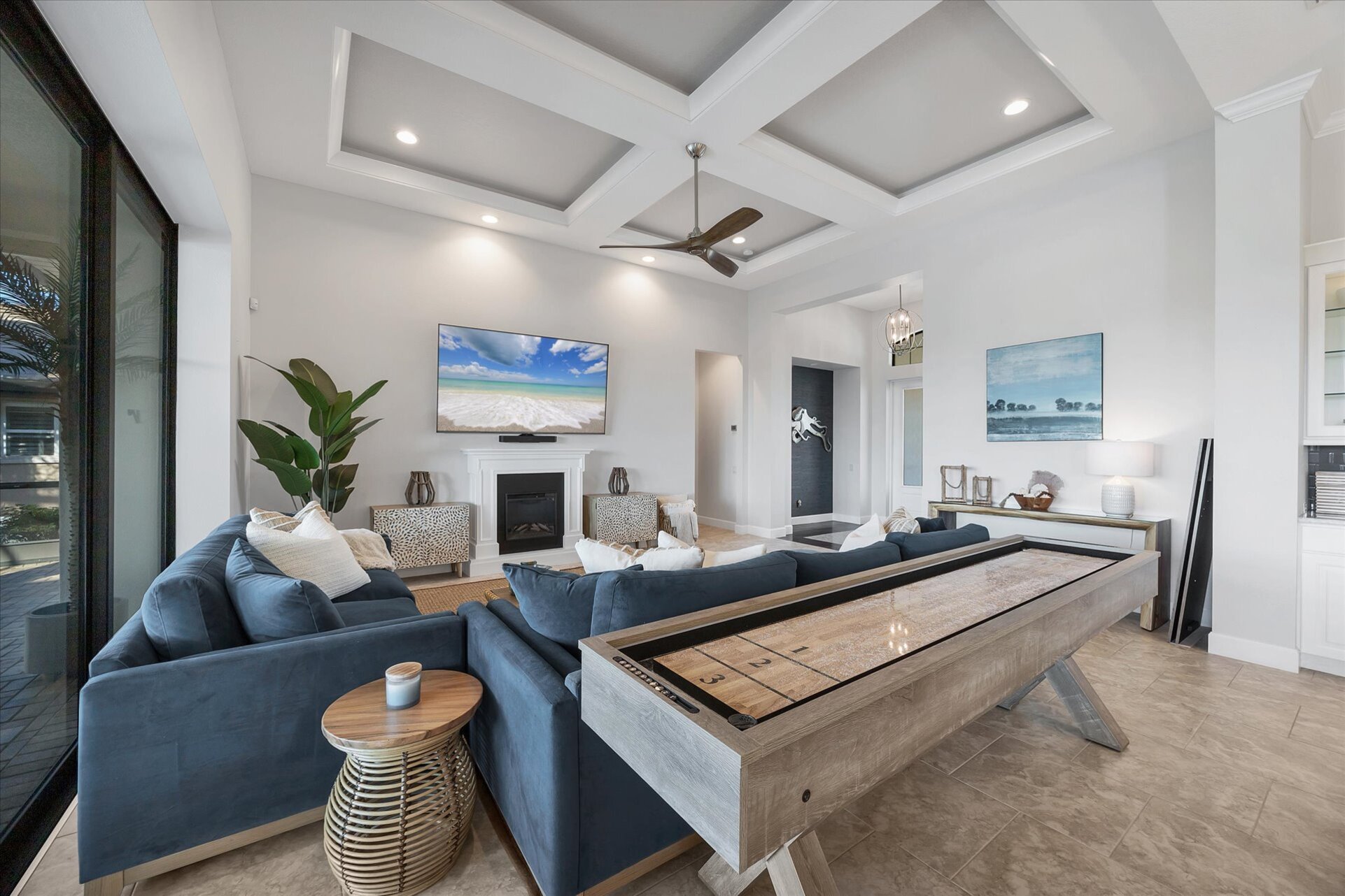 Beautiful, bright, open living space. Living room features ample seating, shuffleboard table, electric fireplace, lanai access, and huge 84-inch Smart TV