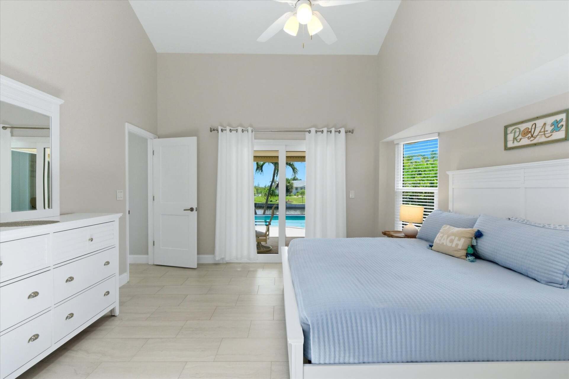 Bedroom 1 - primary bedroom with king bed, attached bathroom, lanai access, and 43" Smart TV